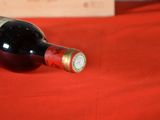 a bottle of wine sitting on a red table cloth