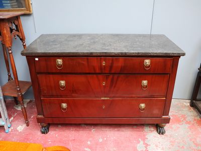une commode avec un plateau en marbre, montée sur roulettes, dans une pièce