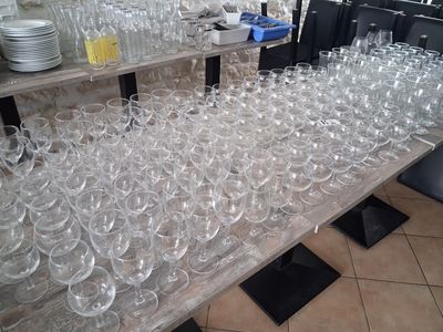 several rows of empty wine glasses on a table in a restaurant