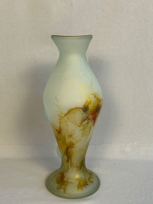 un vase blanc orné d'un motif marron et jaune