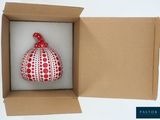 a red and white ornament in a cardboard box