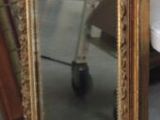 a large mirror sitting on the floor next to a pile of furniture