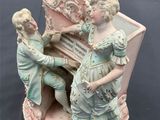 a figurine of two children playing on a piano