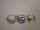 three rings with a stone in the middle and a yellow stone in the middle