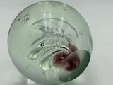 a glass ball with a red flower inside of it