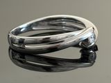 sterling silver ring on a reflective surface with a black background
