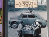 two books are sitting on a table next to an old car