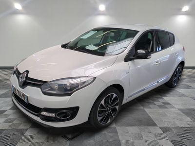 la voiture blanche est garée sur un sol en damier dans le garage