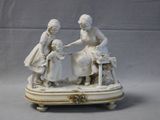 two figurines of women sitting on a table