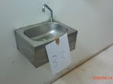 a sink in the corner of a bathroom with a note attached to it