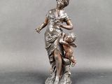 bronze statue of a woman holding a child on her lap