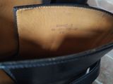 someone is wearing a pair of black shoes with a leather lining