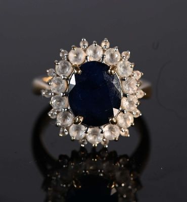 a close up of a ring with a blue stone surrounded by white diamonds