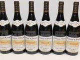 six bottles of wine are lined up in a row on a table