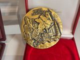 gold medal in a red box on a white surface with a red case
