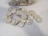 a bag of coins sitting on a table next to a pile of coins
