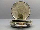 a small silver box with a picture of a bird inside of it