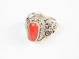 un gros plan d'une bague en argent sertie d'une pierre rouge