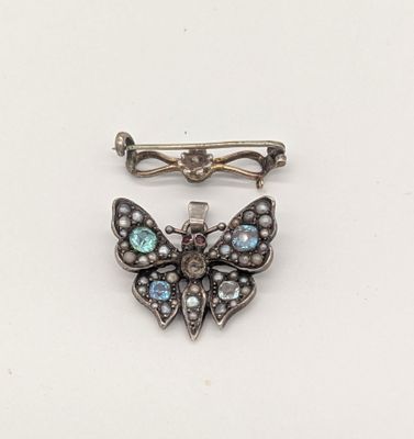 une image représentant une broche en forme de papillon ornée de pierres bleues
