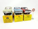 three toy cars are sitting on top of boxes on a white surface