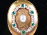 a close up of a gold locke with a pearl and emeralds