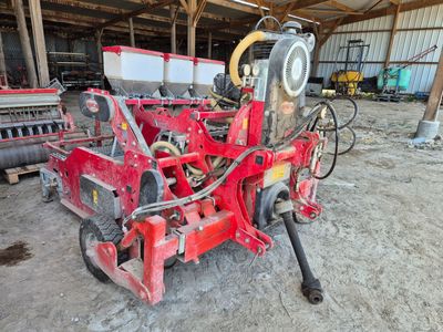 une machine rouge qui est à l'arrêt dans la poussière
