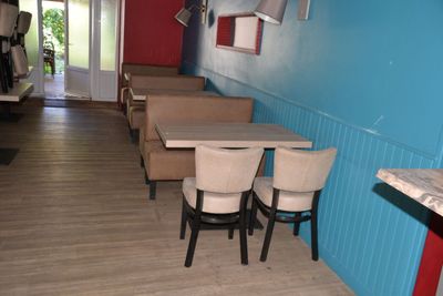 des tables et des chaises dans une pièce aux murs bleus et au parquet