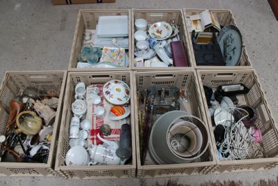 quatre paniers remplis d'objets divers, posés par terre