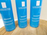 three bottles of la roche - posy are sitting on a wooden table