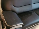 a black leather couch sitting on a hard wood floor