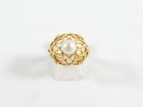 gros plan d'une bague en or avec une perle au centre
