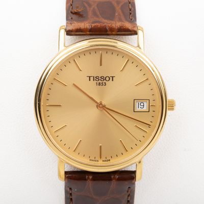 a close up of a gold wrist watch on a white surface