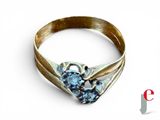 a gold ring with two blue stones on it