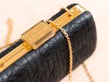 an image of a black purse with a gold chain