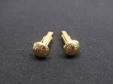 une paire de boucles d'oreilles plaquées or posées sur un tissu noir