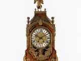 une horloge en or surmontée d'un ange
