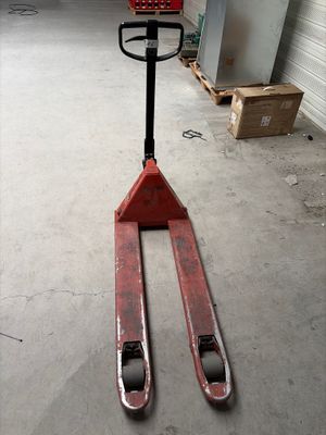 un chariot élévateur garé dans un garage, devant la porte de celui-ci