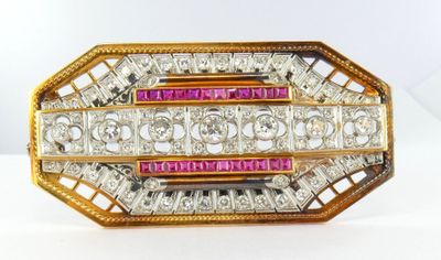 a close up of a gold and pink broochle with diamonds