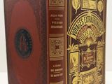 an old book with a brown cover sitting on top of a white table