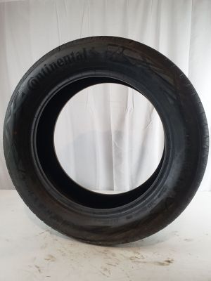 tire on a white surface with a white curtain in the background