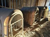 two old stoves sitting in a barn with hay on the ground
