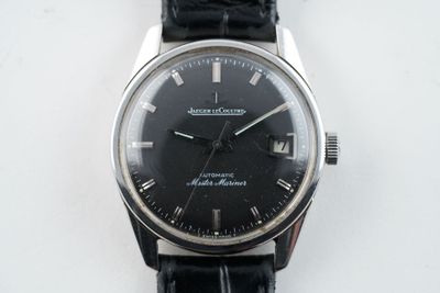 une montre noire avec des chiffres romains sur le cadran
