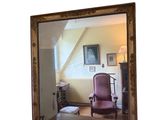 un miroir dans lequel se reflète une chaise dans une pièce