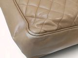 the back of a tan leather purse with a zipper on it