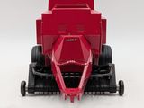 a close up of a red toy truck on a white surface