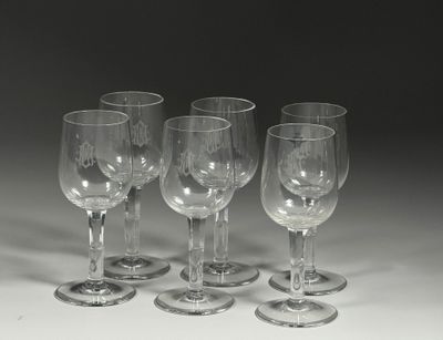 plusieurs verres à vin vides sont alignés sur une surface blanche
