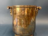 an image of a brass vase with handles on a grey background