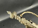 brass figurine of a bird on a branch with an arrow in its beak