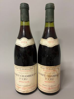 two bottles of red wine sitting next to each other on a table