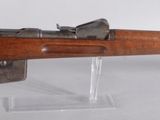 an old model of a rifle on a stand on a white surface